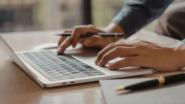 Person writing a blog post on a laptop